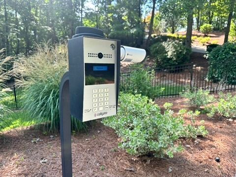 A security camera is mounted on a pole next to a keypad.