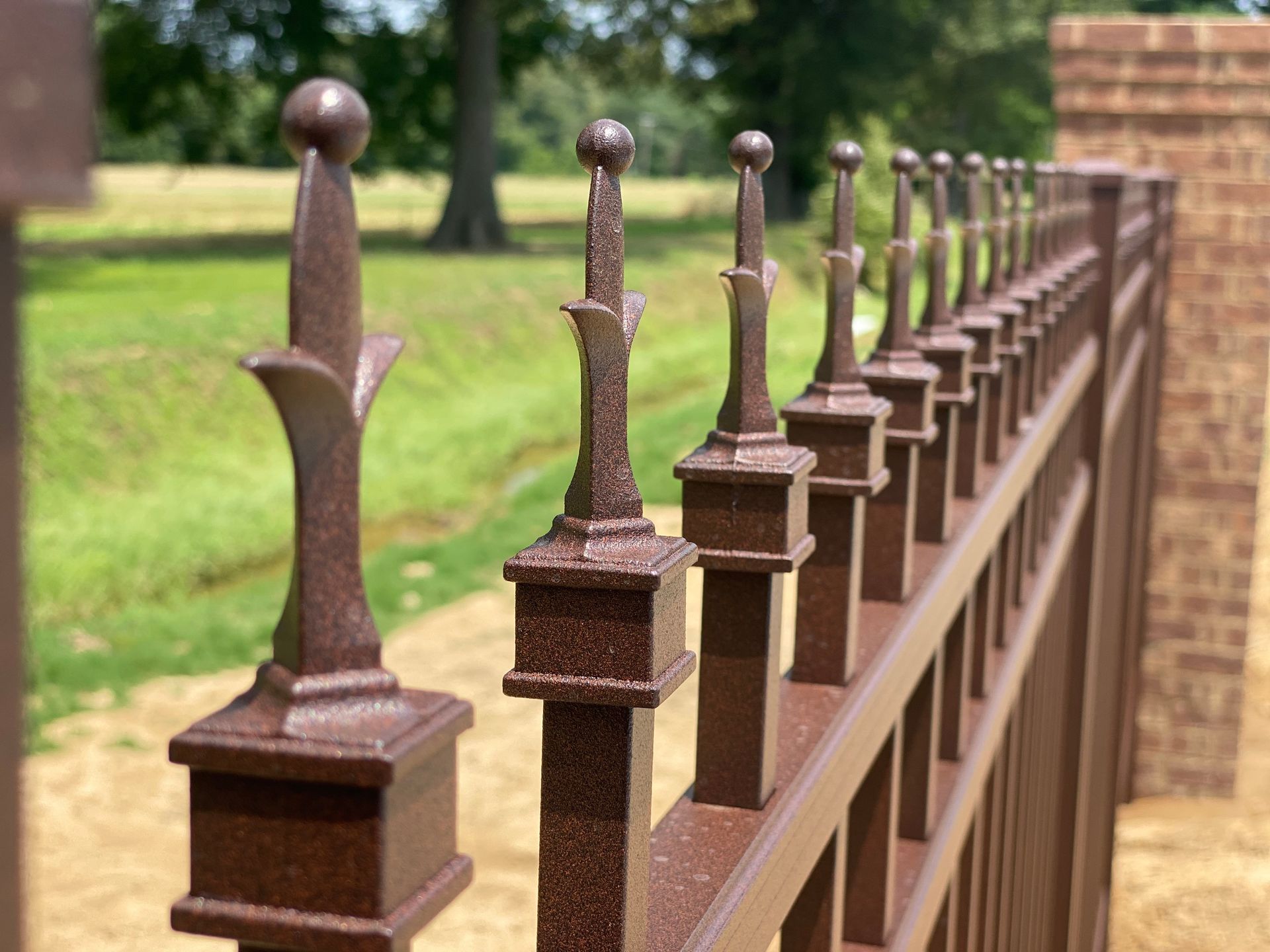 A close up of a brown fence with a brick wall in the background