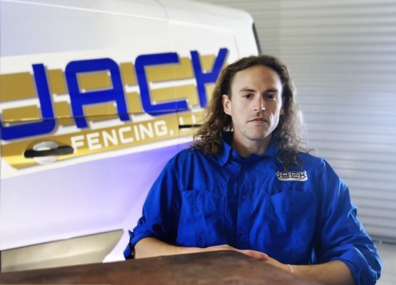A man sitting in front of a jack fencing van