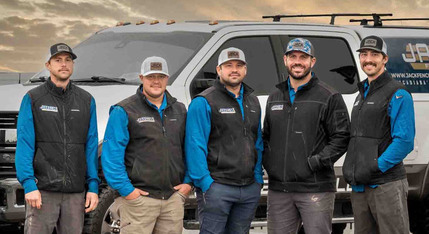 A group of men are posing for a picture in front of a truck.