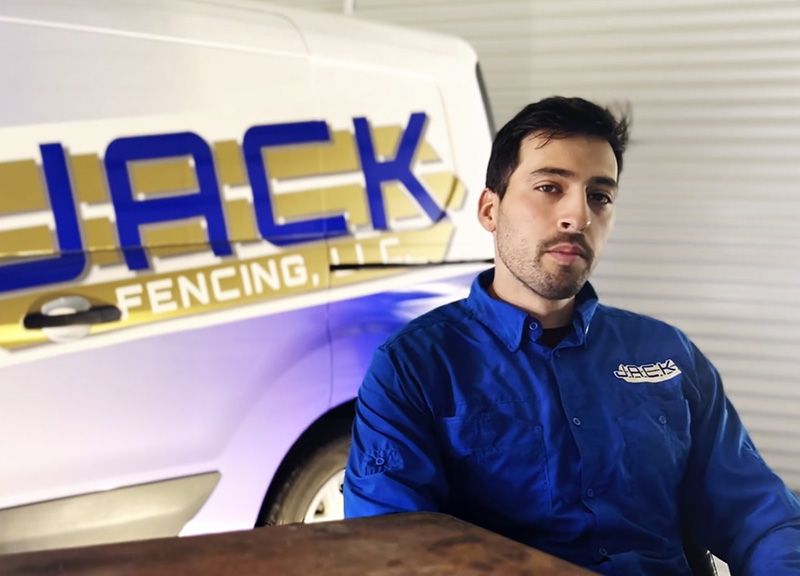 A man sitting in front of a jack fencing truck