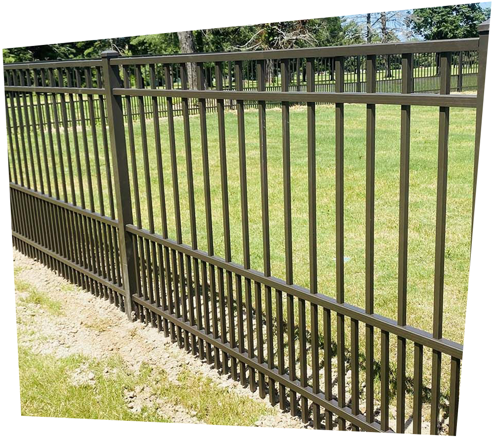 A black wrought iron fence surrounds a lush green field.