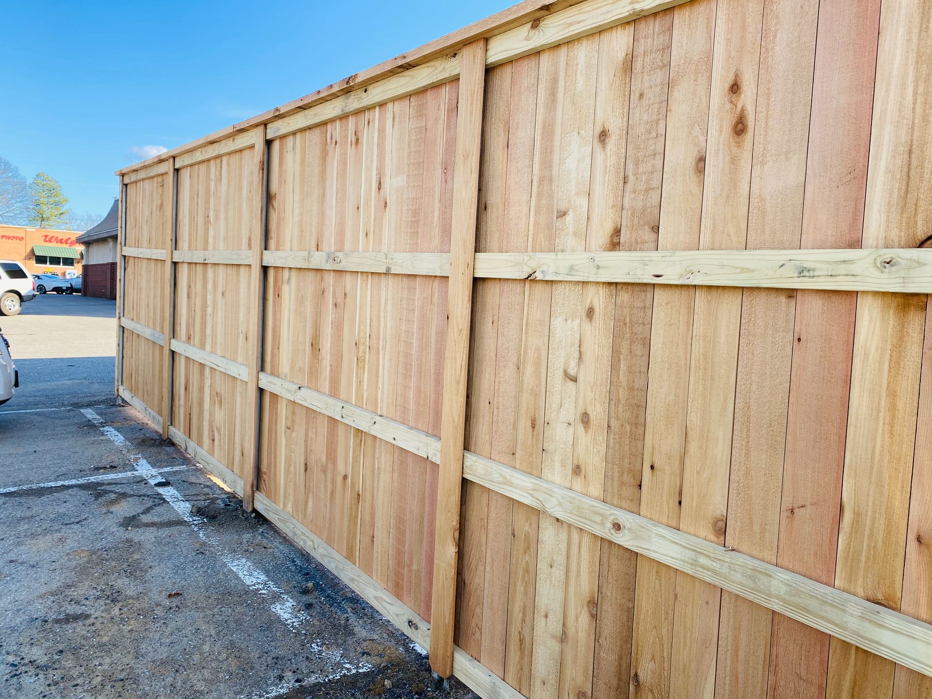 A wooden fence is sitting in a parking lot.