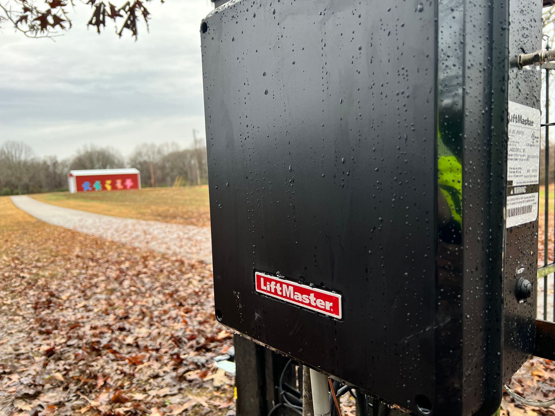 A black box with the word liftmaster on it is sitting on top of a pole.