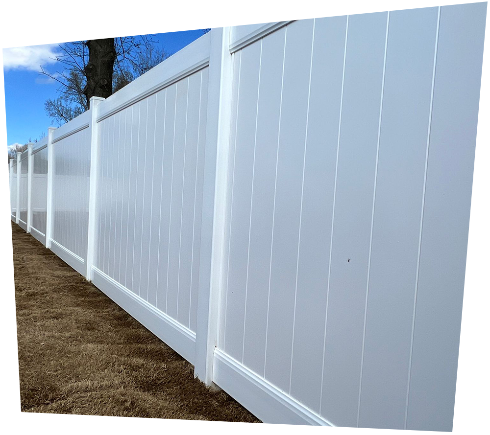 A white vinyl fence with a tree in the background