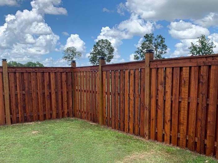 A wooden fence is sitting in the middle of a lush green field.