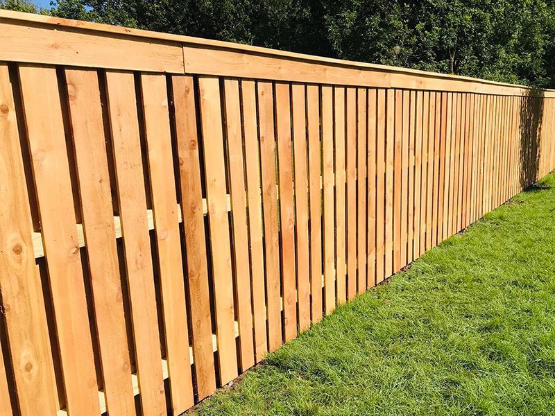 A wooden fence is sitting on top of a lush green lawn.