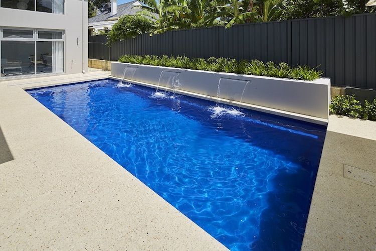 A Swimming Pool With a Fountain Leading Into It — Aqualine Pools in Avoca, QLD