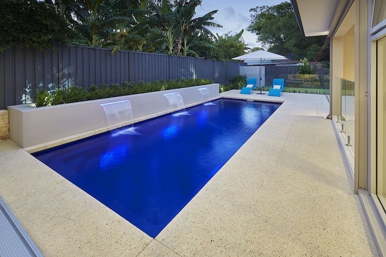 A Swimming Pool With a Aggregate Concrete Around It — Aqualine Pools in Innes Park, QLD