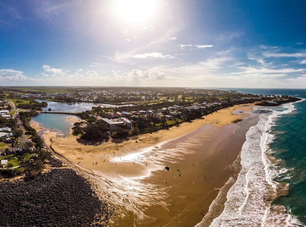 An Aerial View of a Beach With Waves Crashing on the Shore — Aqualine Pools in Bargara, QLD