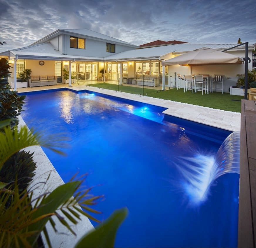A House With a Large Swimming Pool in Front of It — Aqualine Pools in Childers, QLD