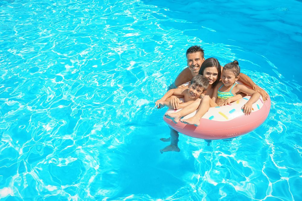 Happy Family In Swimming Pool — Aqualine Pools in Svensson Heights, QLD