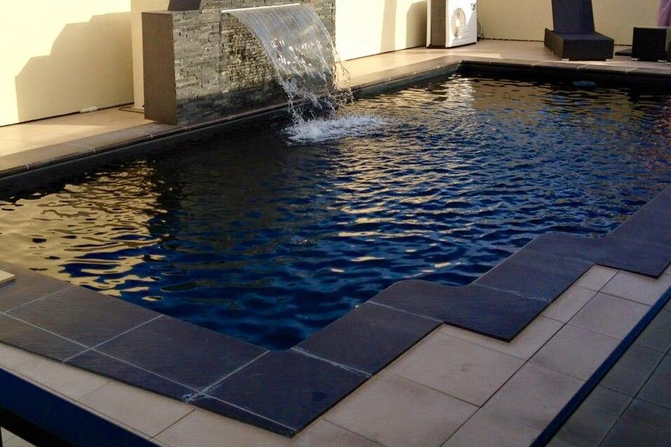 A Pool With Fountain Feature On Side