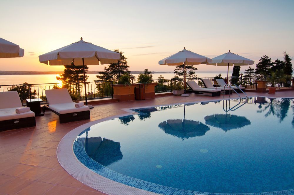 Backyard With a Pool, Spa, and Patio Area, Featuring Blue Water and a Modern House.