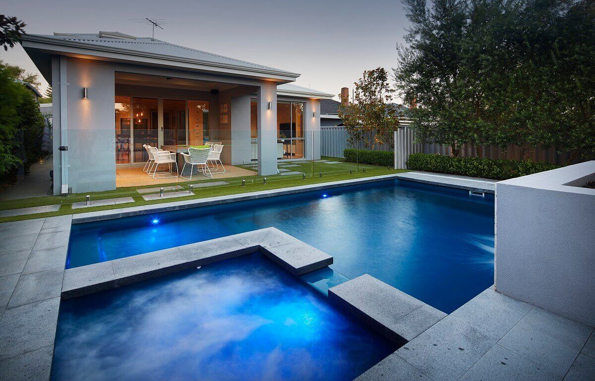 A Large White House With a Swimming Pool in Front of It — Aqualine Pools in Innes Park, QLD
