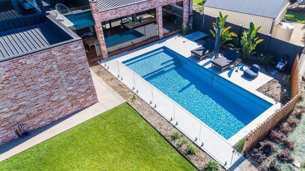 An Aerial View of a Large Swimming Pool in the Backyard of a House — Aqualine Pools in Innes Park, QLD