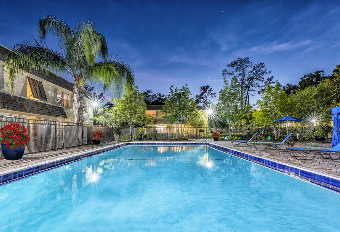 There is a large swimming pool in the middle of a residential area.