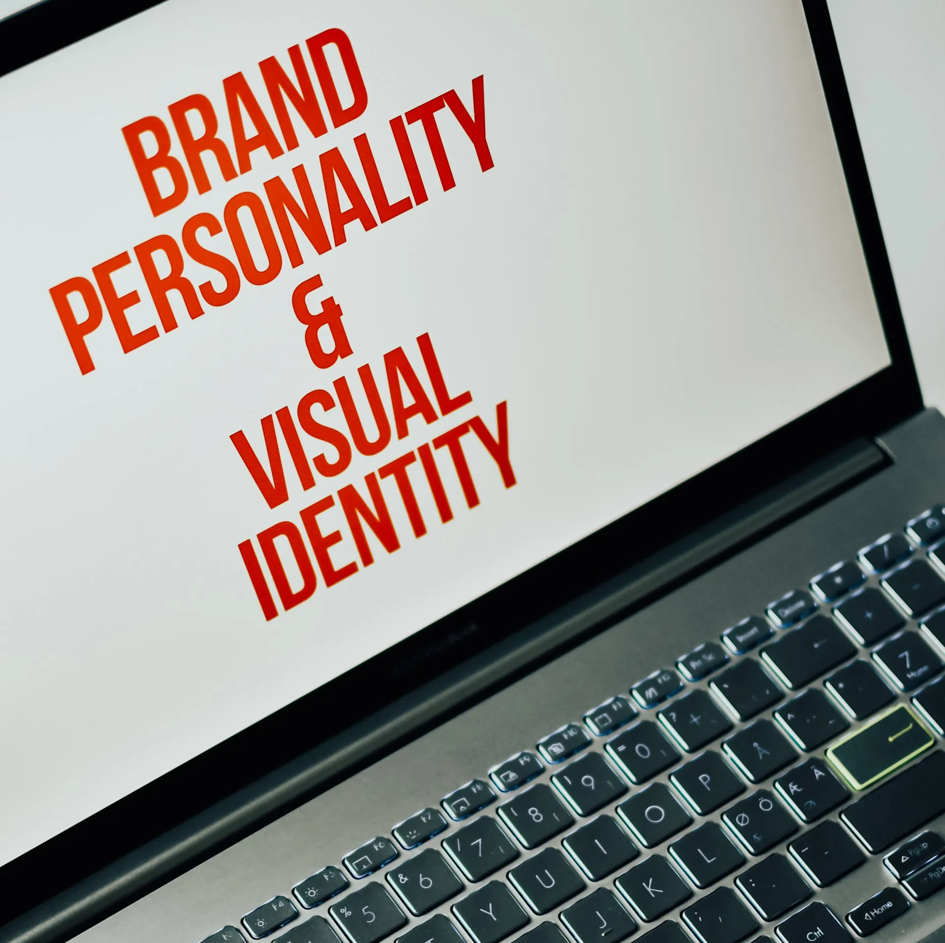 A laptop with the words brand personality and visual identity on the screen