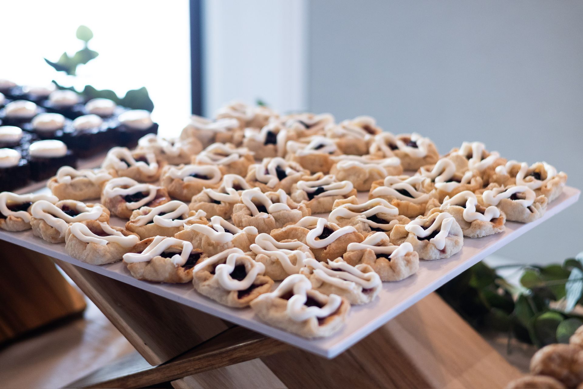 Cookies arranged on a white serving platter, some with jam filling.