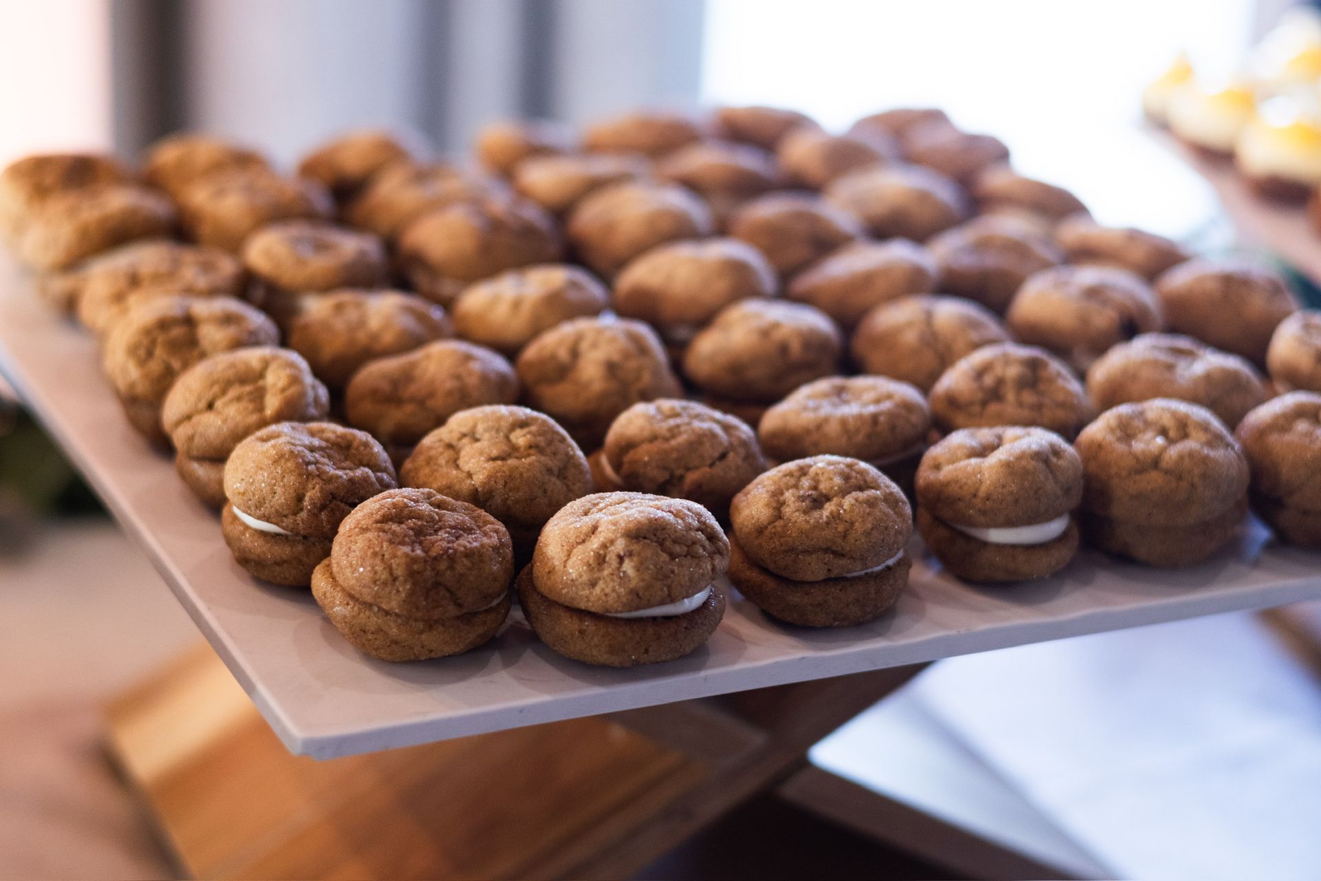 Tray of sandwich cookies with white cream filling.
