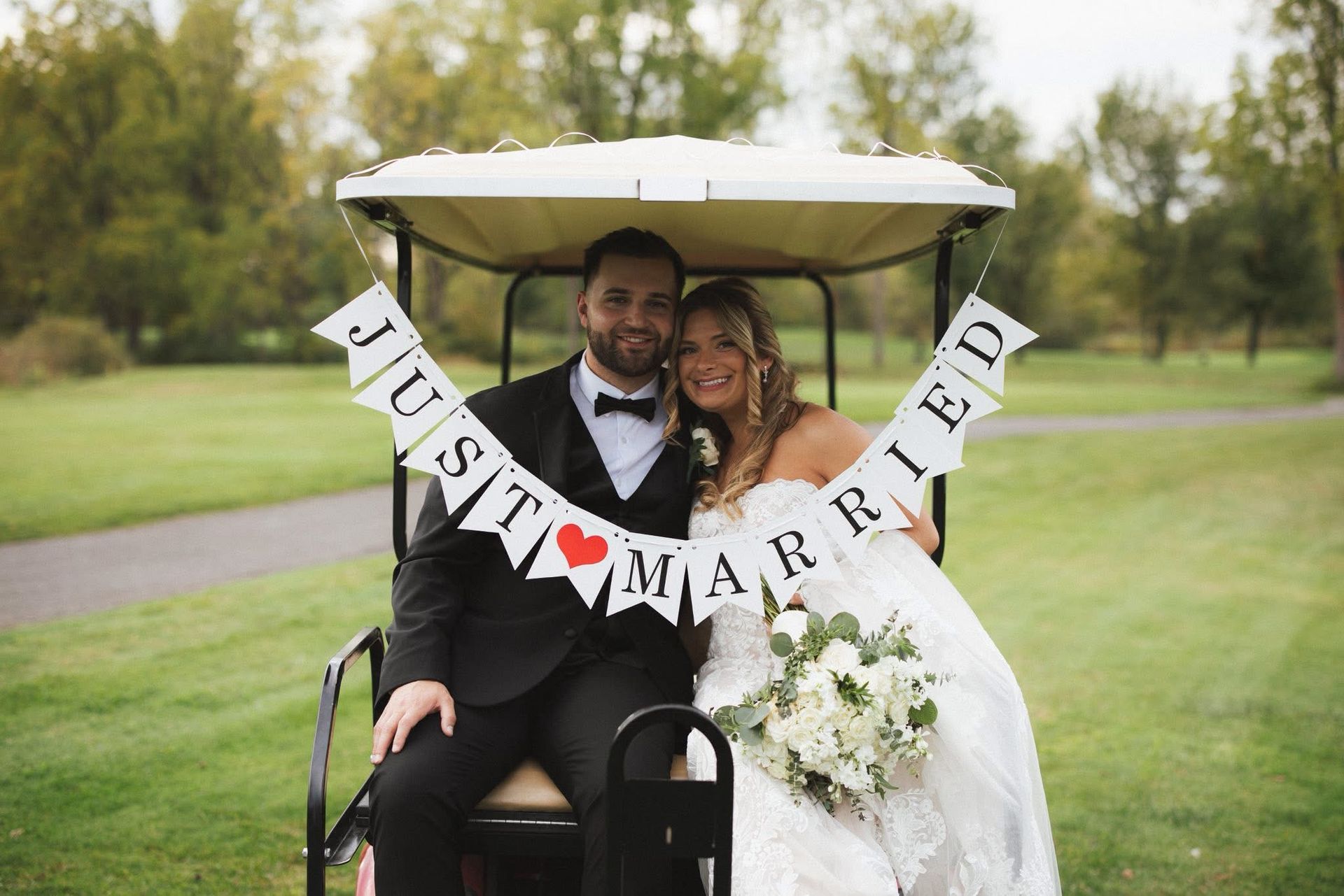 Newlyweds in golf cart with 
