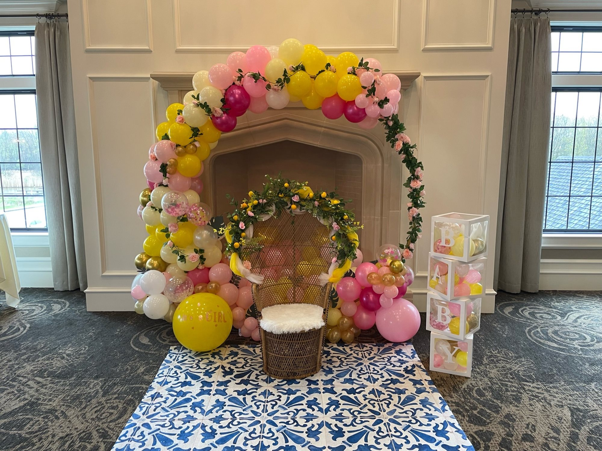A fireplace decorated with balloons and flowers for a baby shower.