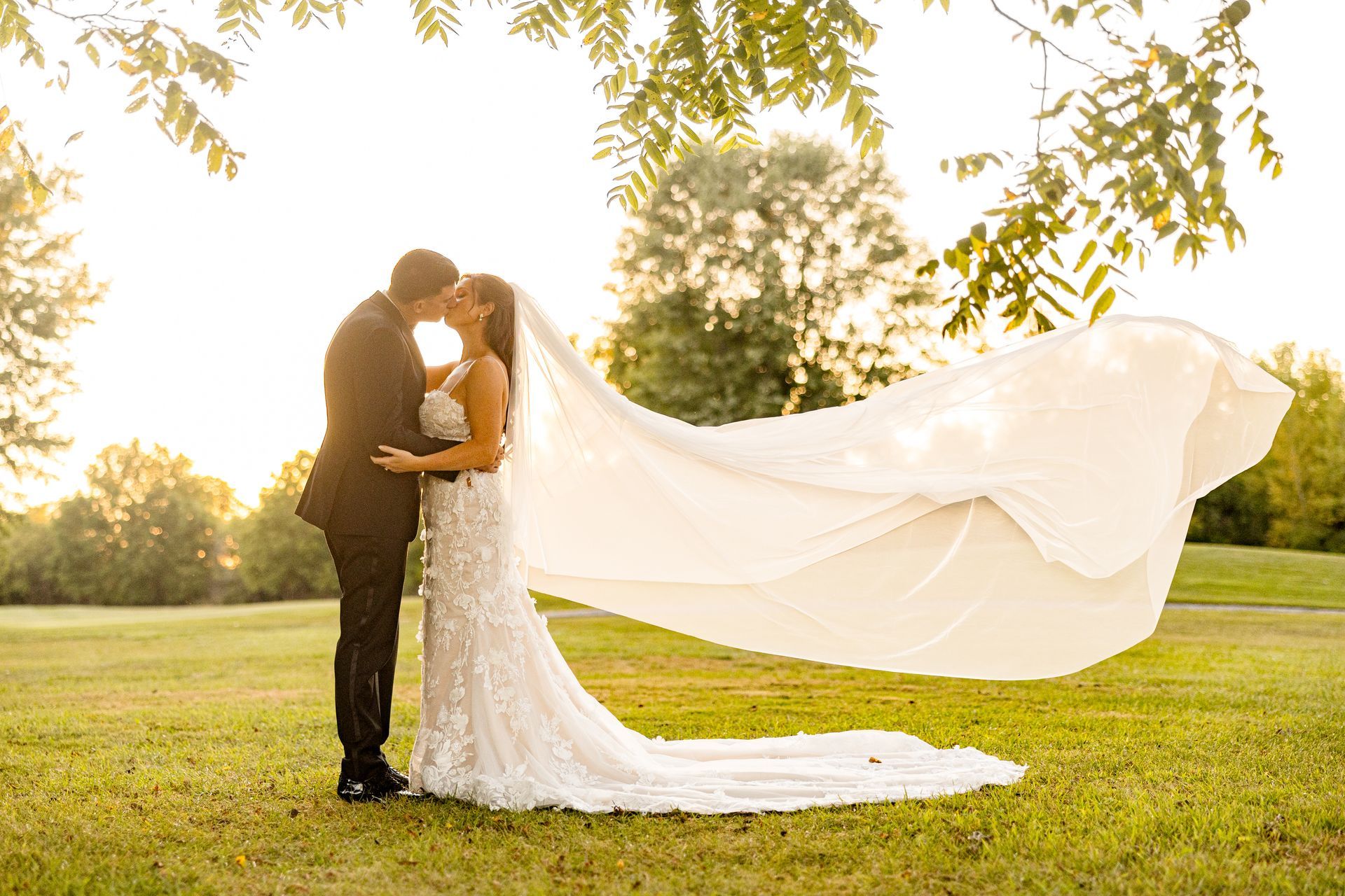 Floral arrangement with hydrangeas, roses, and other blooms. Chandelier in the background.
