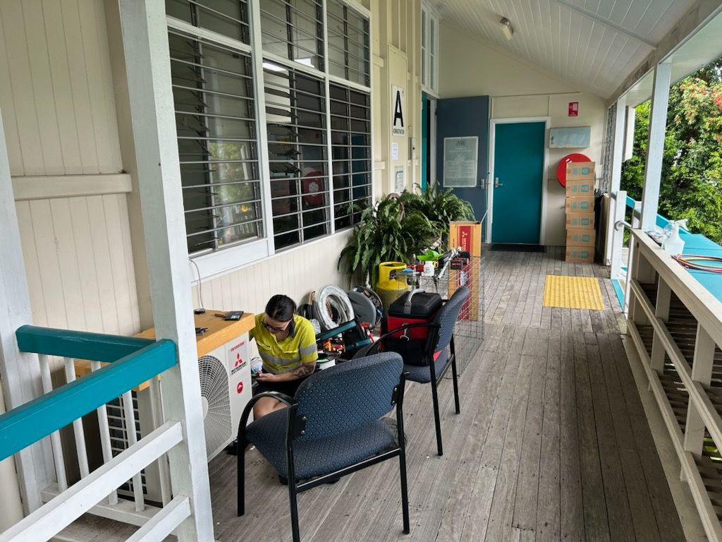 Male Technician Repairing Air Conditioner At Home — Mingleford Electrical Airconditioning Solar & Gas In Landsborough, QLD