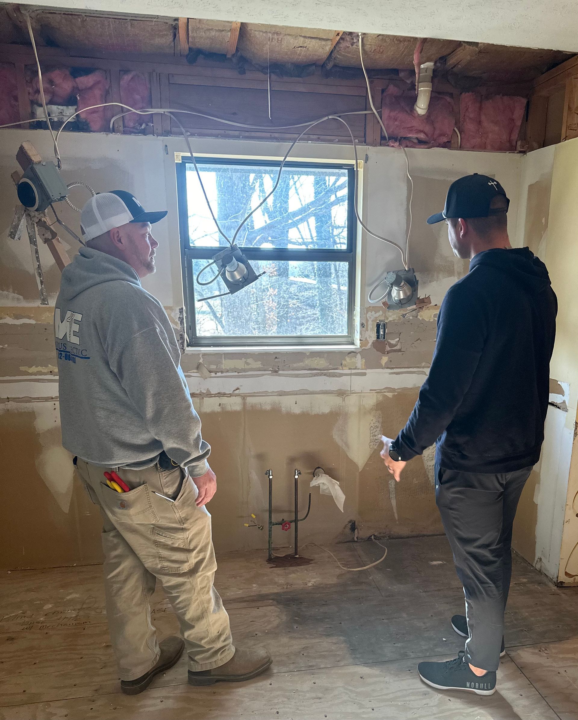 Two licensed electricians for Mingus Electric repairing an electrical issue in a Louisville home.