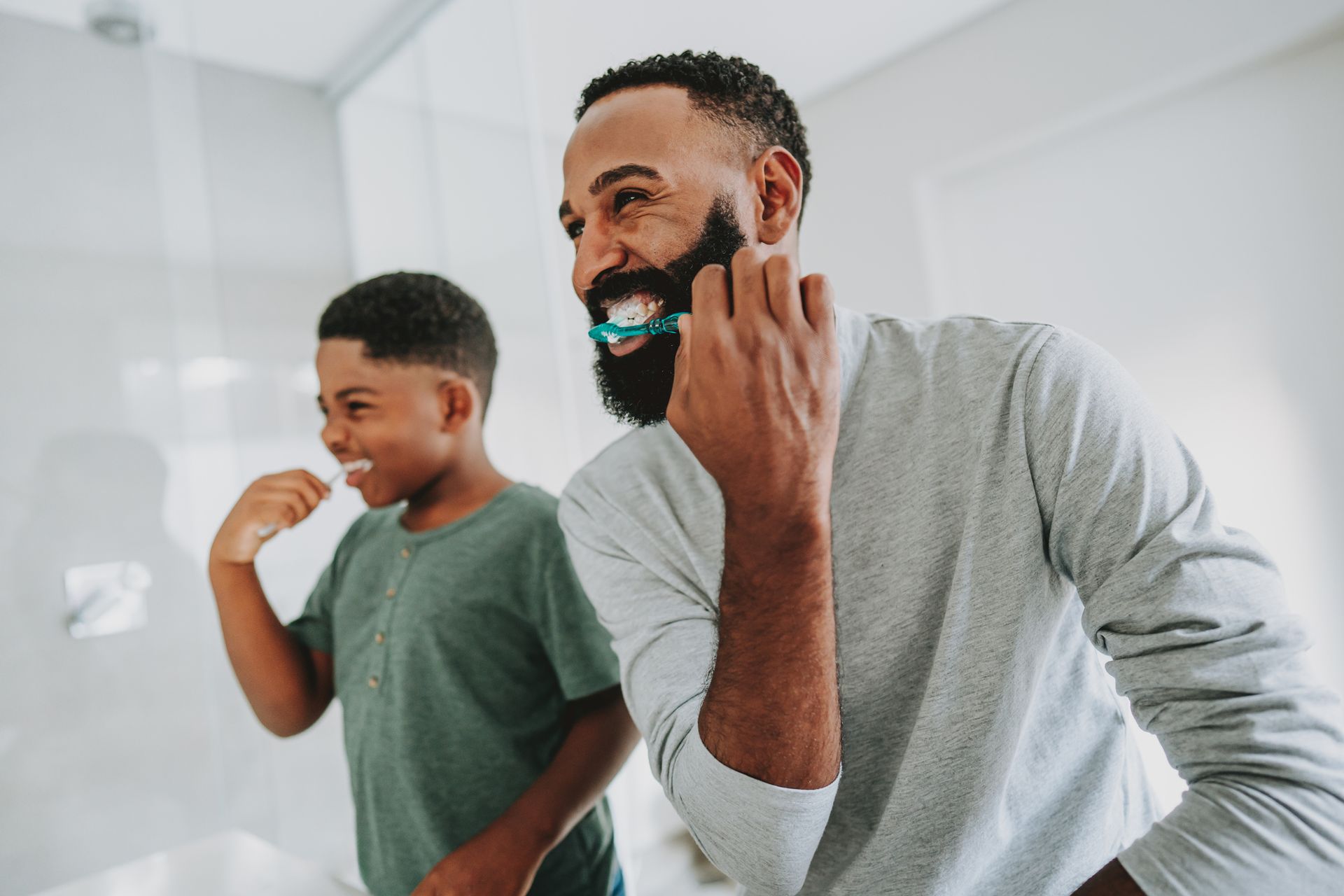 Man and child brushing teeth