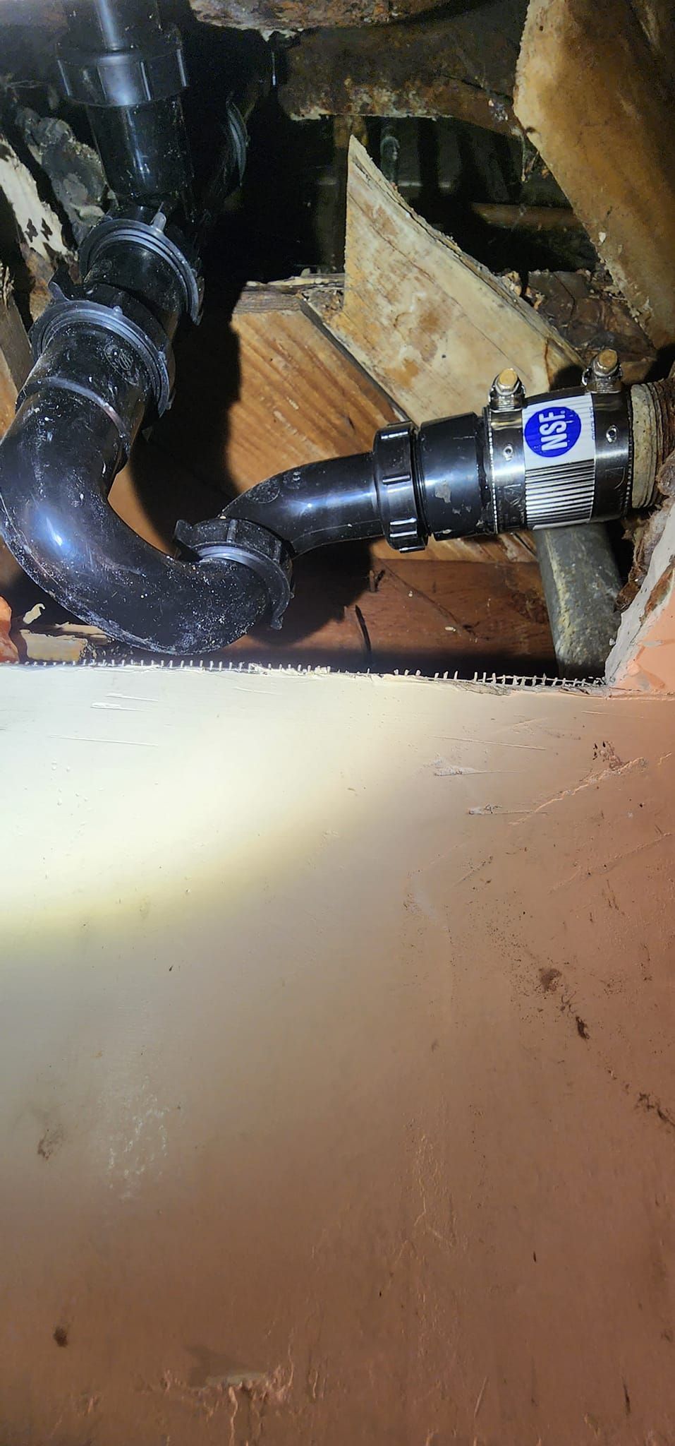 A close up of a plumbing pipe in a basement.