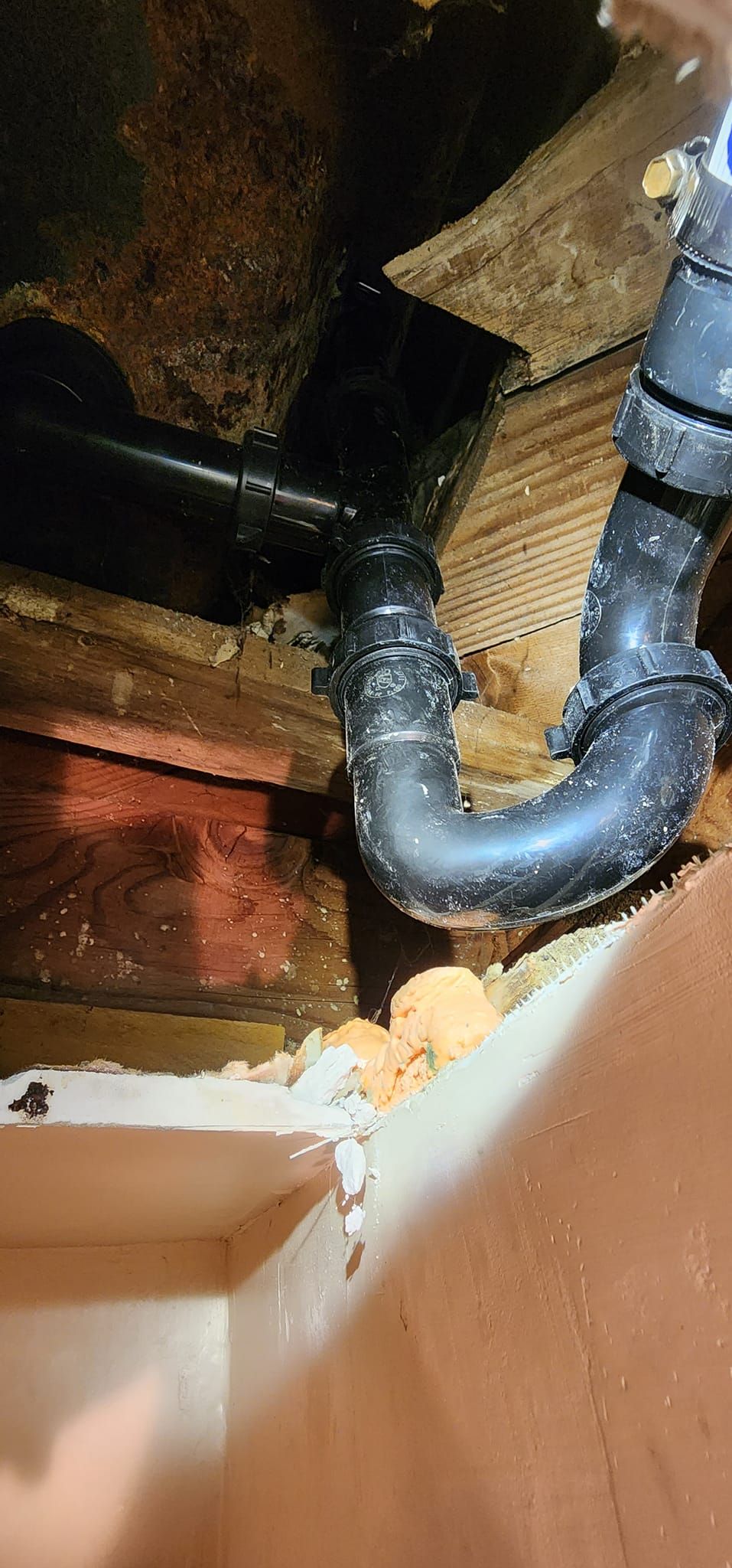 A black pipe is hanging from the ceiling of a room.