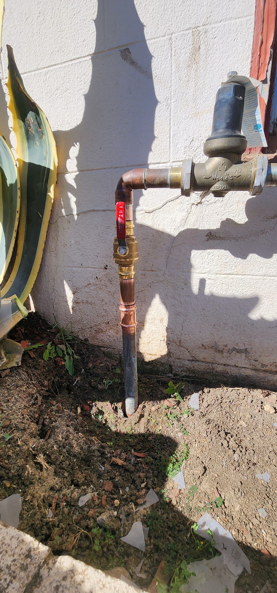 A hose is attached to a faucet on the side of a building.