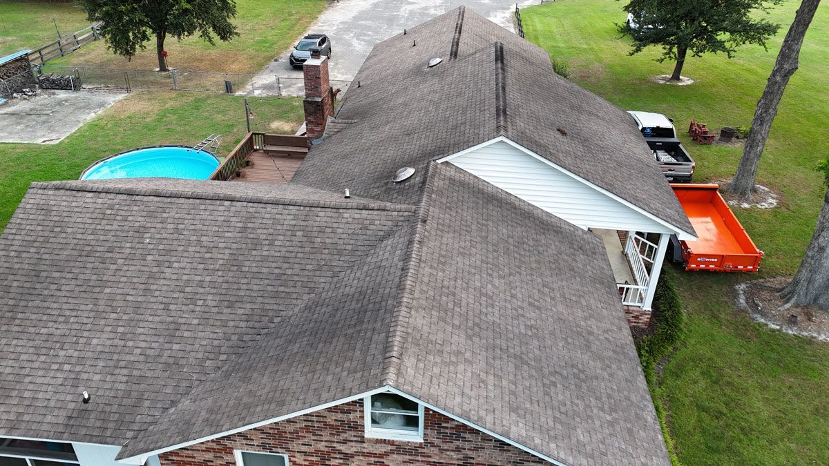 An aerial view of a house with a roof that is being repaired.