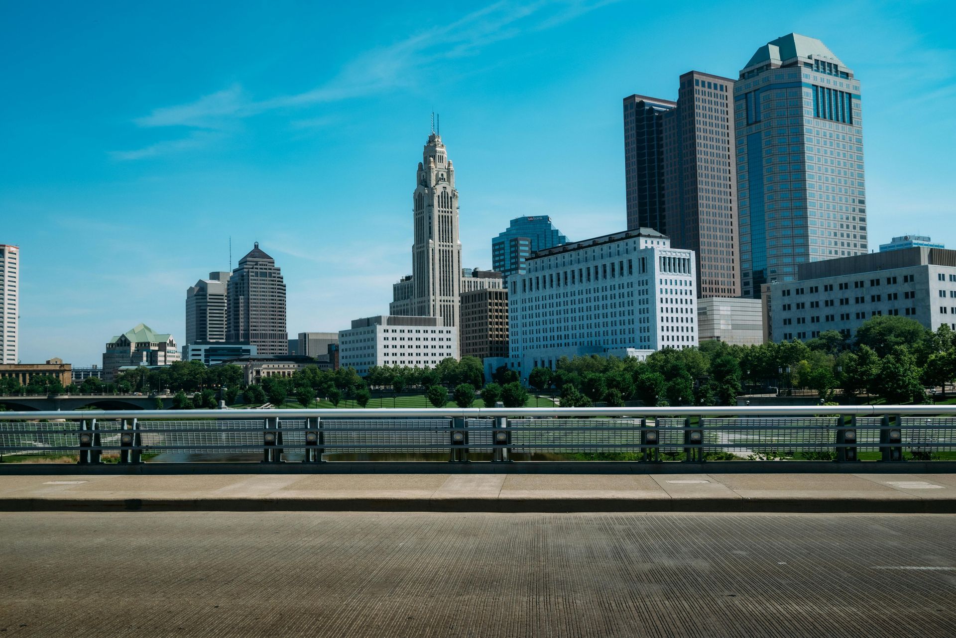 A bridge over a body of water with a city skyline in the background.
