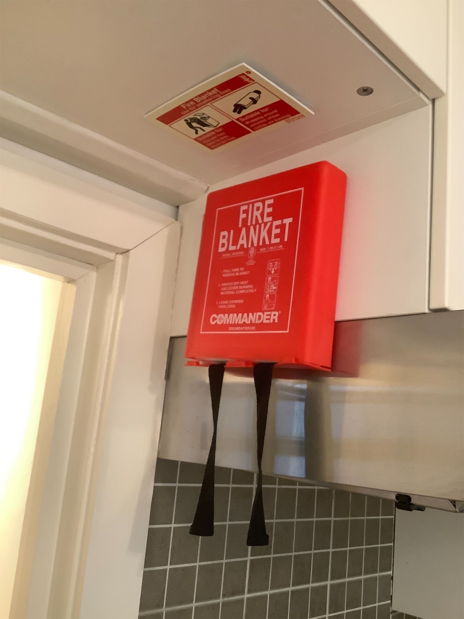 Fire blanket mounted on kitchen cupboard – safety equipment documented