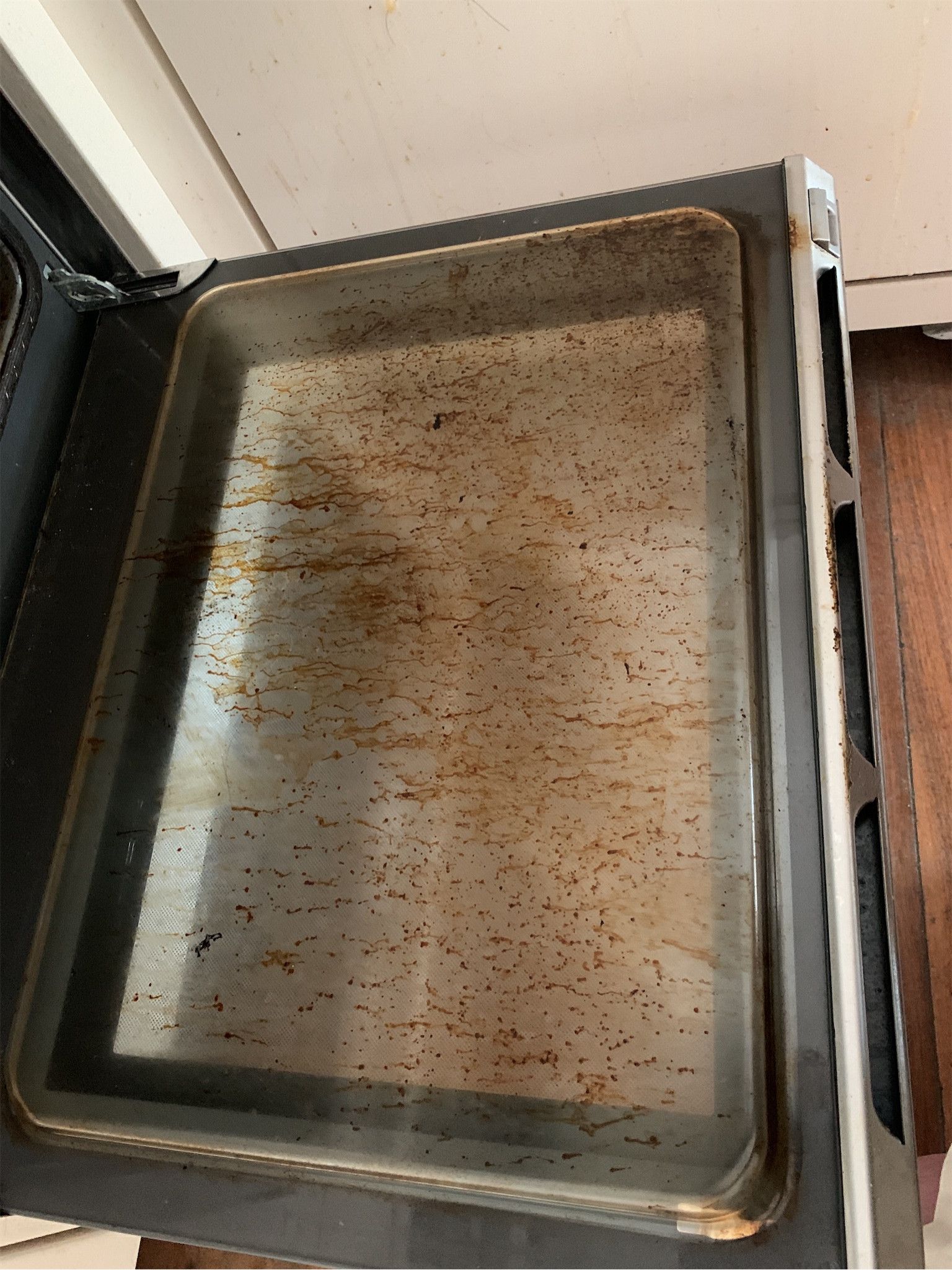 Oven door glass with heavy grease and baked-on residue – check-out report