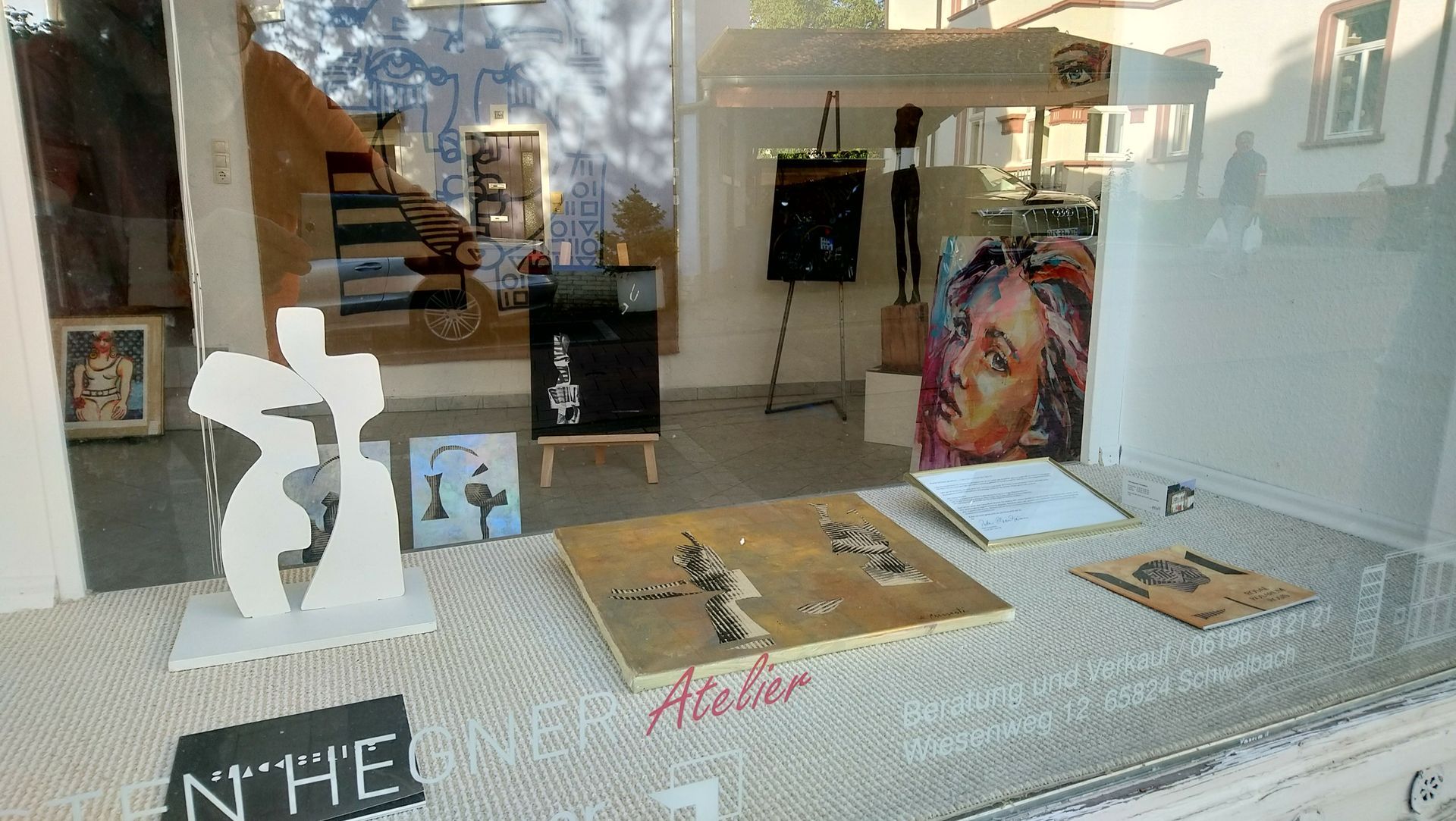 Ein Fenster mit einem Schild mit der Aufschrift „Atelier“ darauf