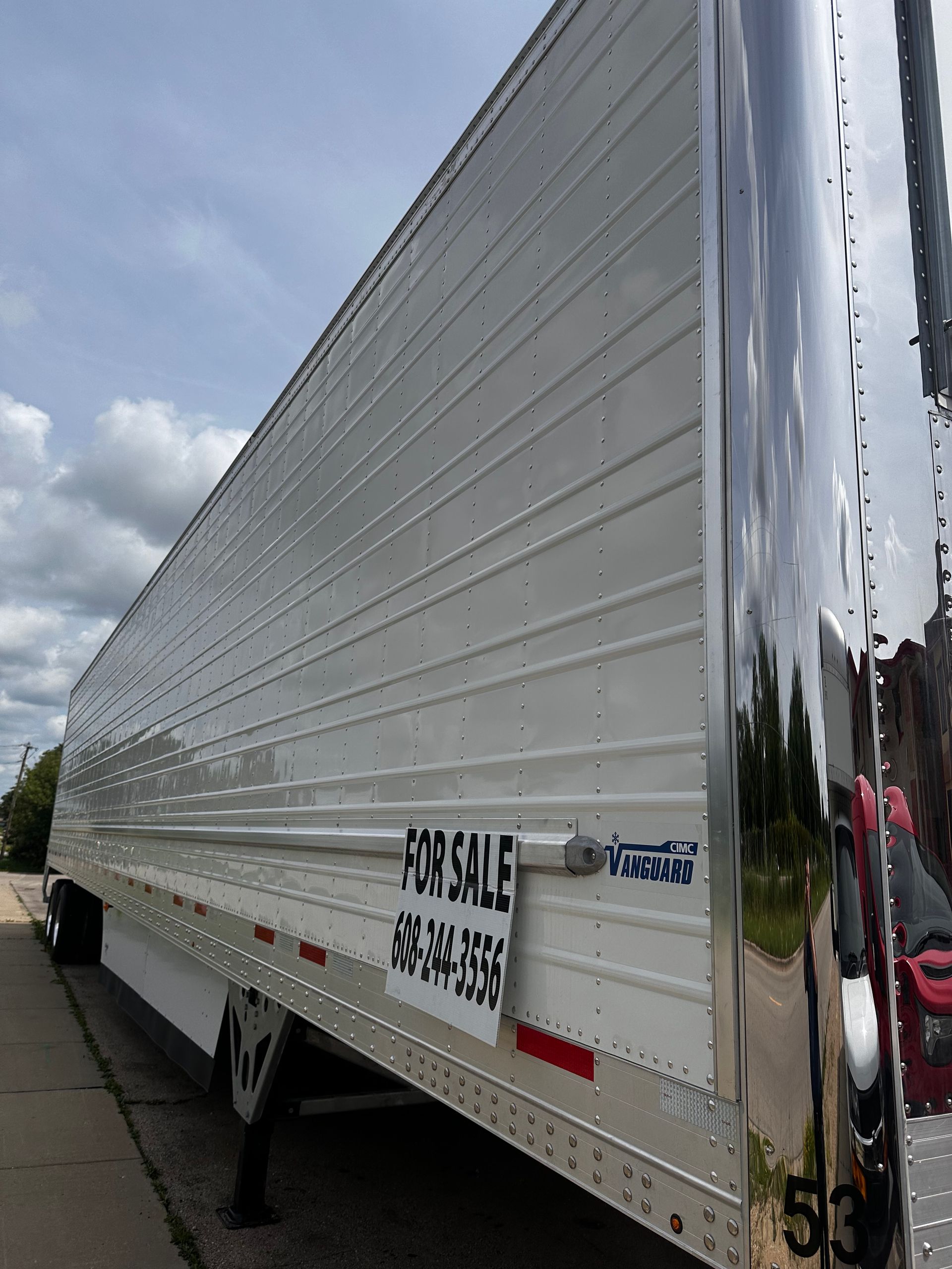 A for sale trailer is parked on the side of the road