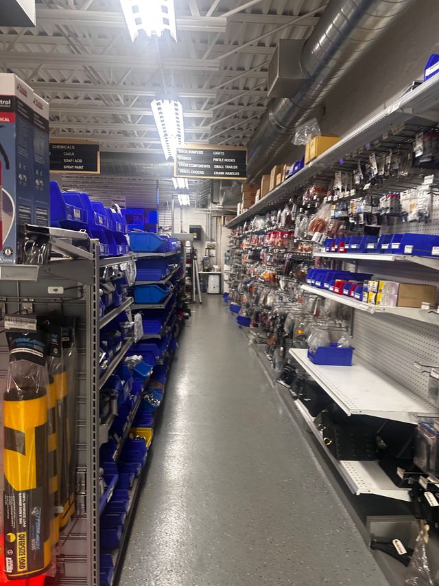 A long aisle in a hardware store with lots of shelves