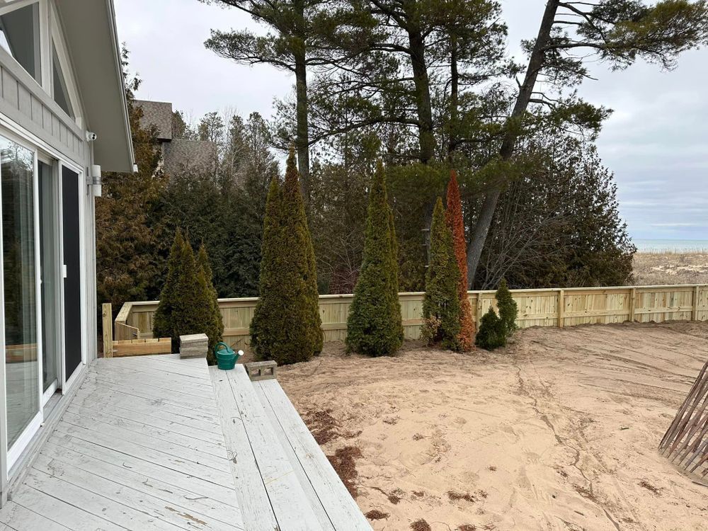 A deck with a fence and trees in the background