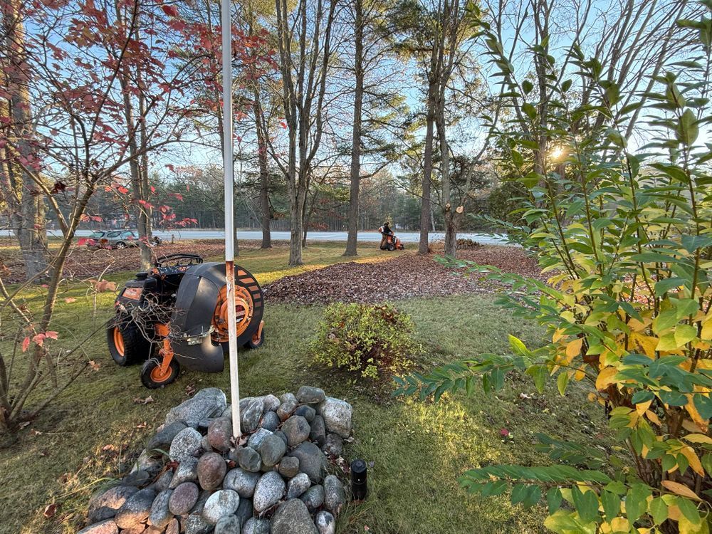 A tractor is parked in a yard next to a pile of rocks.