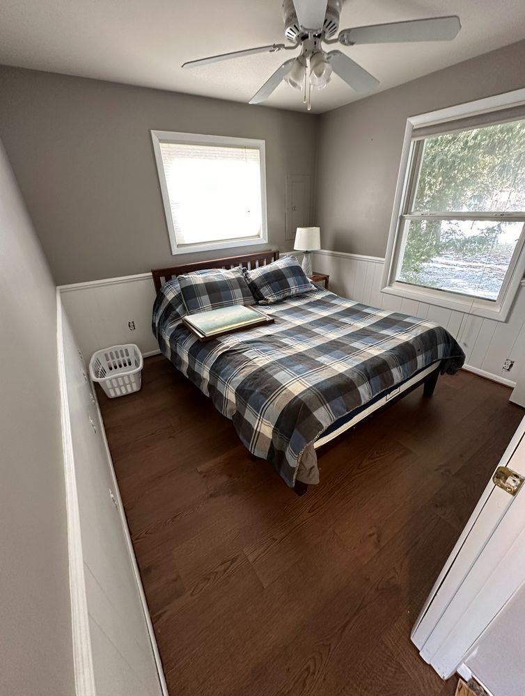 A bedroom with a bed and a ceiling fan.