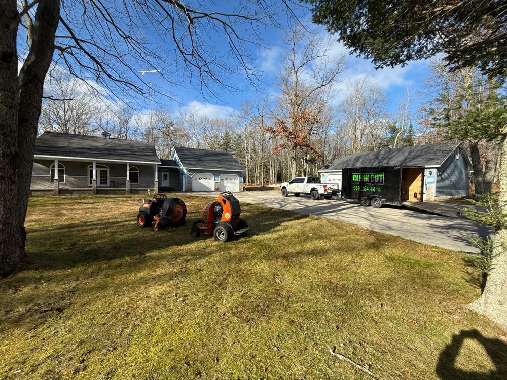 A tractor is parked in the grass in front of a house.