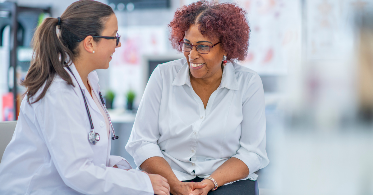 Doctor and patient in a medical office, smiling and conversing.