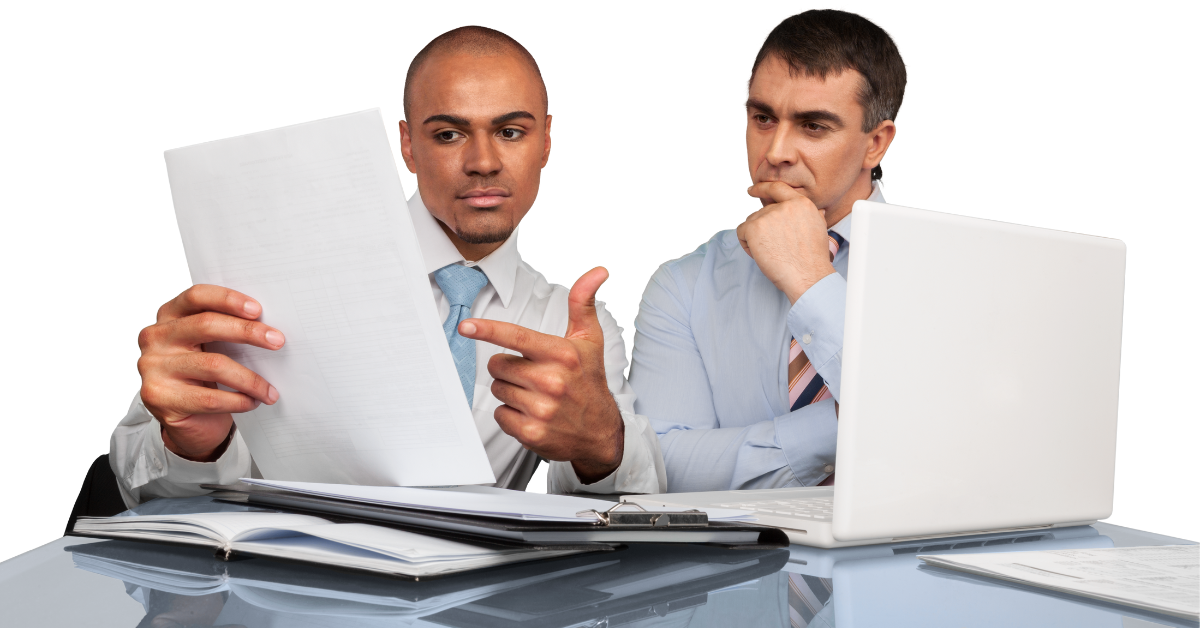 Two men reviewing documents at a desk, one points, the other thoughtful.