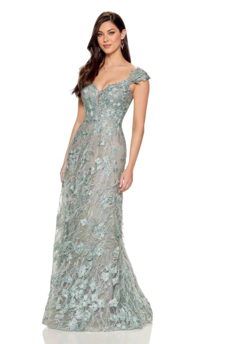 Woman in a blue, off-the-shoulder formal gown with a slit, posing against a white background.