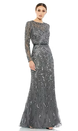 Woman in gray, long-sleeved, beaded gown, standing with hand on hip. Black belt, floor-length.