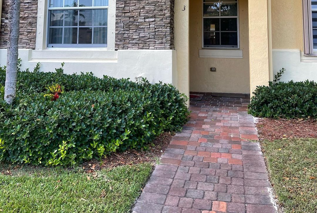 A brick walkway leading to the front door of a house.