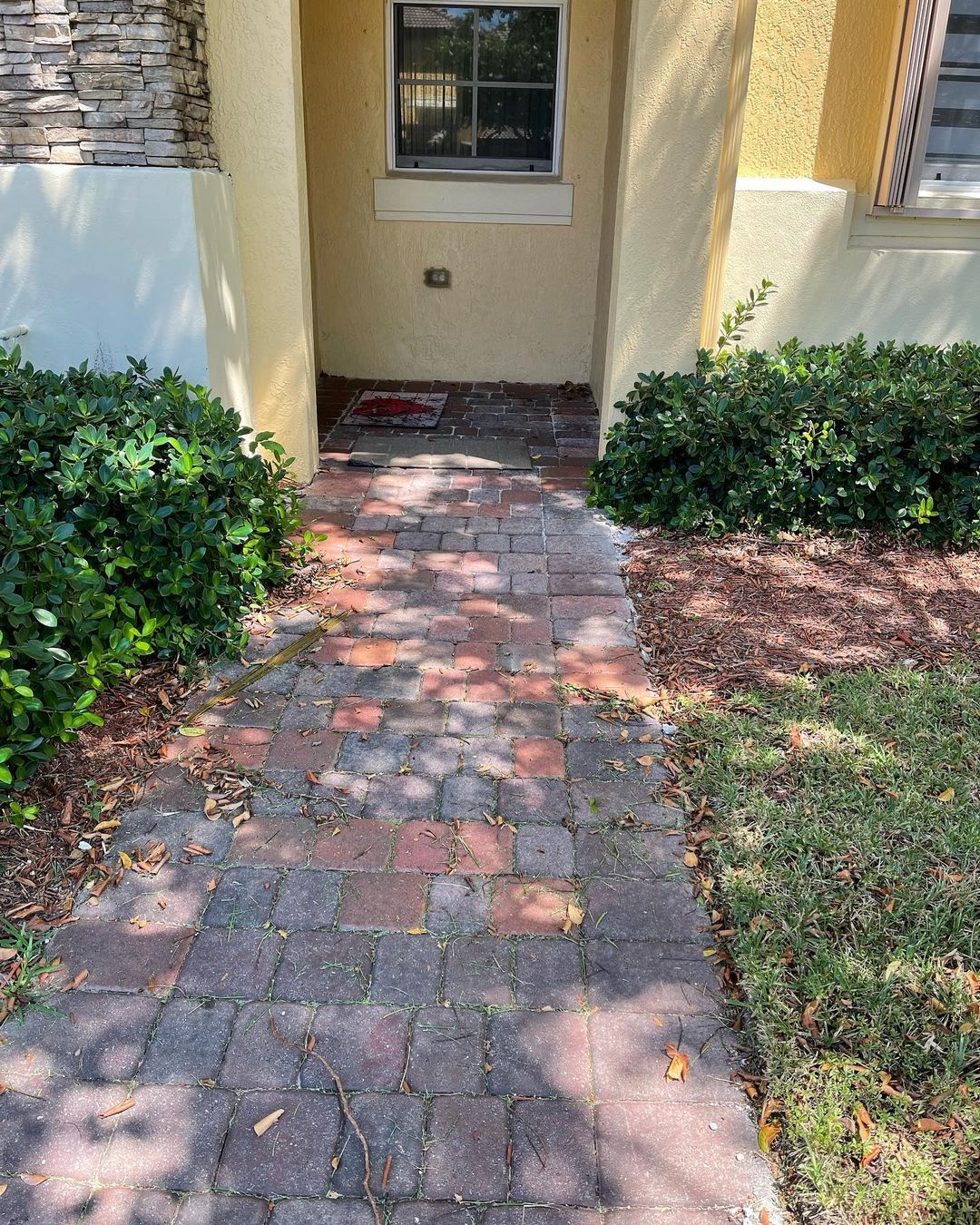 A brick walkway leading to the front door of a house.